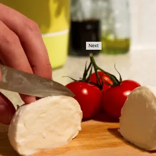 a person cutting a piece of cheese