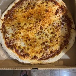 a person standing in front of a box of pizza