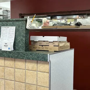 a counter with pizza boxes on it