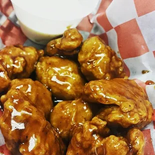 a basket of chicken wings with sauce