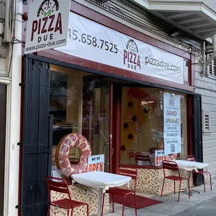 outside of a restaurant with tables and chairs
