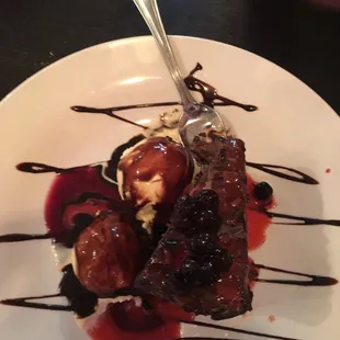 a piece of cake with ice cream and chocolate sauce