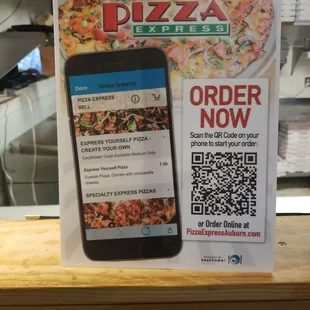 a phone and a pizza order sign