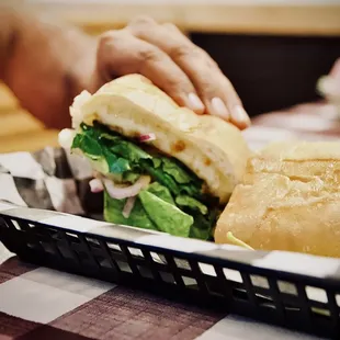 a person putting a sandwich in a basket