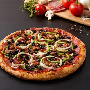 a pizza with olives, peppers, and sausage