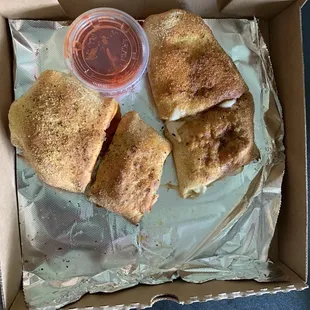 an open box with a sandwich and a drink