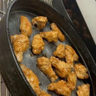 chicken wings cooking in a frying pan