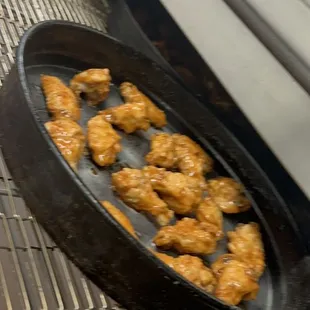 a frying pan filled with fried chicken