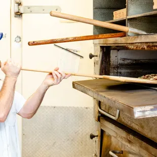 a pizza being taken out of an oven