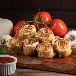 a wooden cutting board with tomatoes and garlic