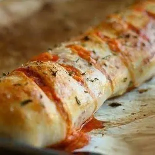 a cheesy bread roll on a baking sheet