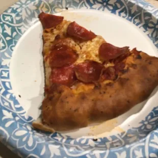 a slice of pepperoni pizza on a paper plate