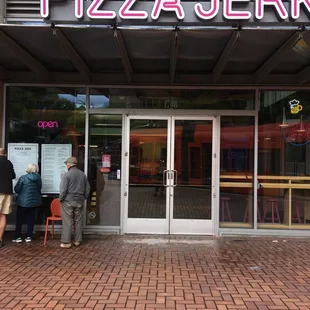 people standing outside of a restaurant