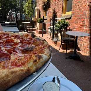 Pepperoni pizza with some seats and the fountain.