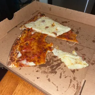 Old pizza with fresh cheese on top.