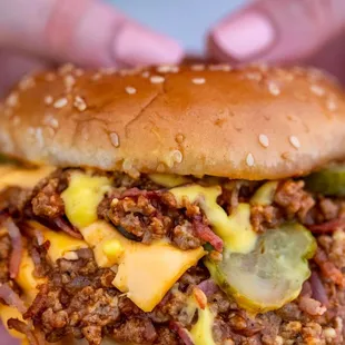 a person holding a large hamburger