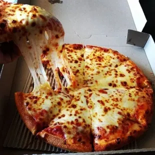 a hand holding a slice of pizza