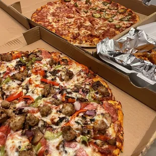 two different pizzas in boxes
