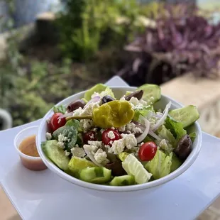 Greek Salad: Romaine, Onion, Tomatoes, Cucumbers, Kalamata olives, Feta Cheese, and Pepperoncini. Served with Red Wine Vinaigrette.