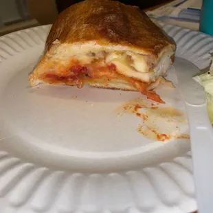 a half eaten pizza on a paper plate