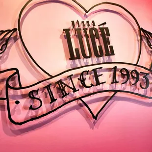 a heart shaped sign with a ribbon around it