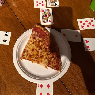 a slice of pizza and playing cards