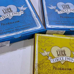 three boxes of pizza and a box of pizza
