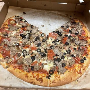 a half eaten pizza in a cardboard box