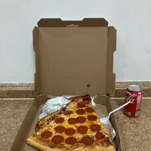 a slice of pepperoni pizza in a box