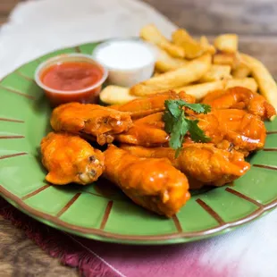 a plate of chicken wings and french fries