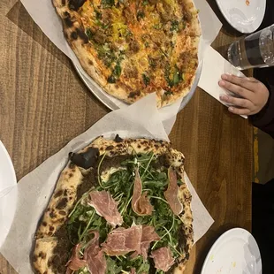 two pizzas on a wooden table