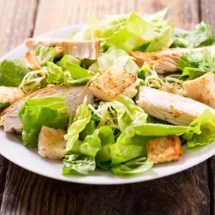 a plate of salad with chicken and lettuce