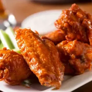 a plate of buffalo wings and celery