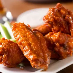 a plate of buffalo wings and celery