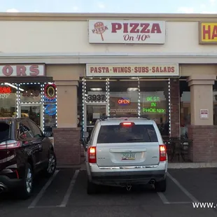 two cars parked in front of a pizza hut