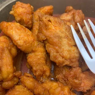 a fork in a bowl of fried chicken