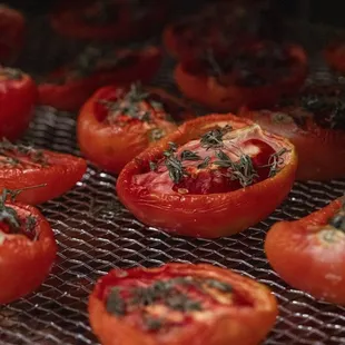 tomatoes being cooked on a grill