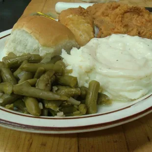 a plate of food including green beans, mashed potatoes, and fried chicken