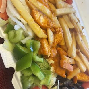 french fries and vegetables in a styrofoam container