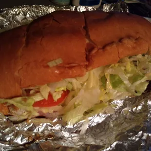 a sandwich with lettuce and tomatoes