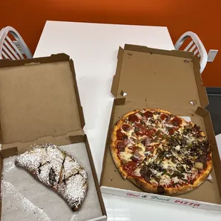 two pizzas in boxes on a table