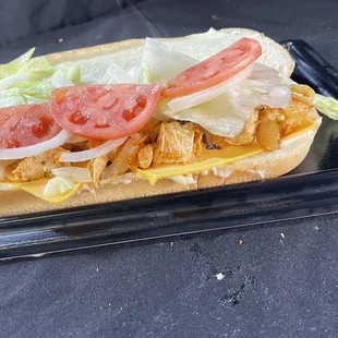 a chicken sandwich with lettuce and tomatoes