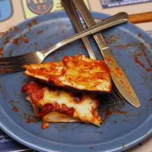 half eaten pizza on a blue plate