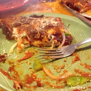 a slice of pizza on a green plate with a fork