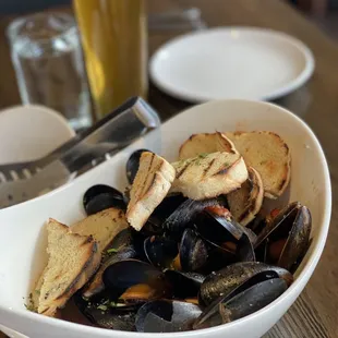 a bowl of mussels and bread