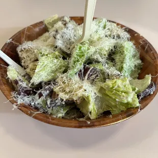 a wooden plate with a salad in it