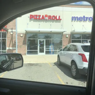 a car parked in front of a pizza parlor