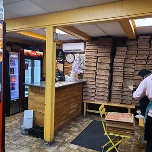 a woman standing in a pizza shop