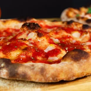 two pizzas on a wooden cutting board