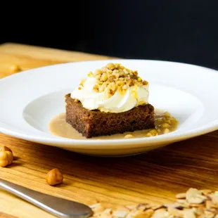 a piece of cake with whipped cream and nuts